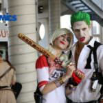 Due cosplayer in costume, uno nei panni di Harley Quinn e l'altro di Joker, posano all'evento ROMICS a Roma, celebrando fumetti e cultura pop.