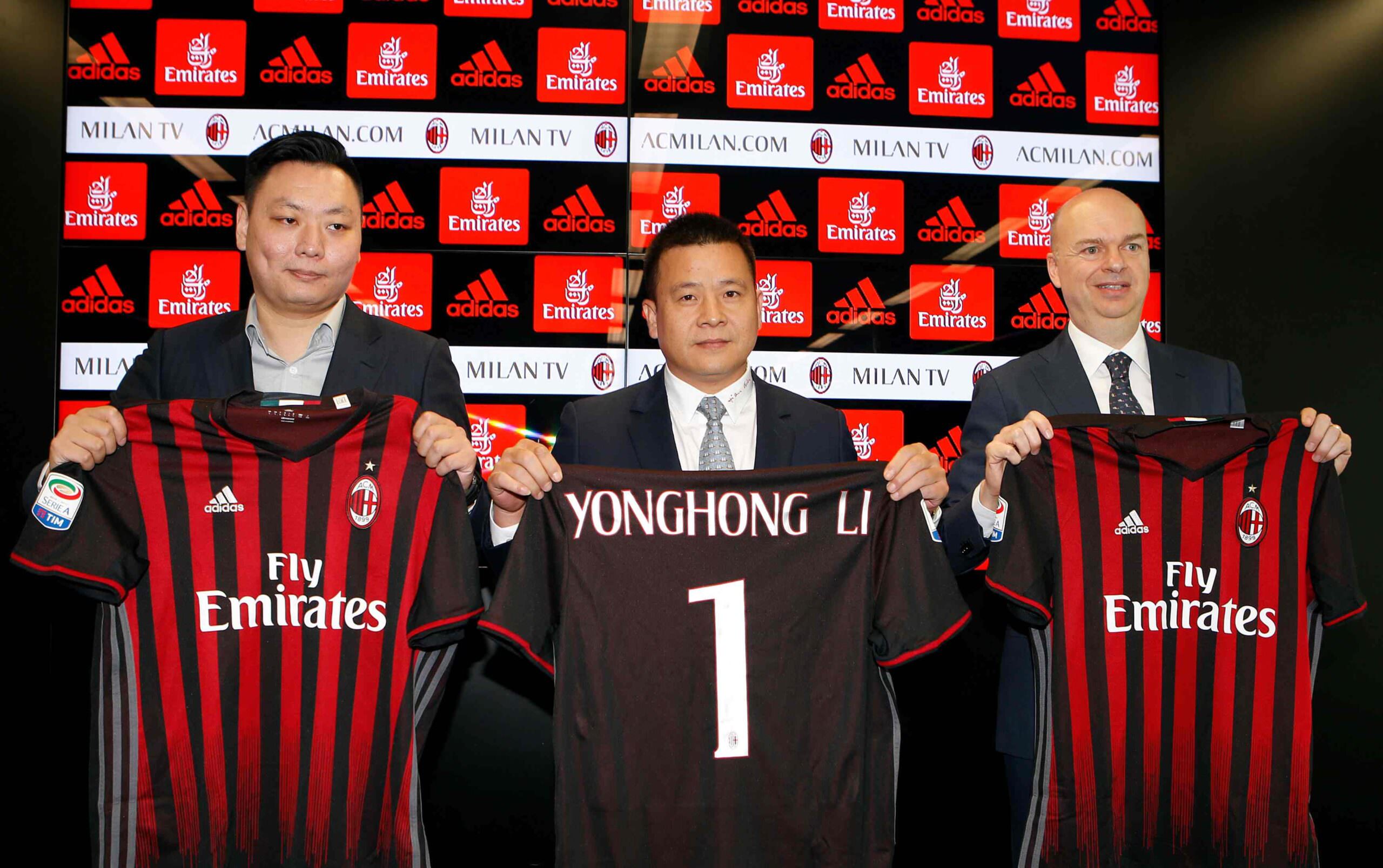 Cerimonia di presentazione di Yonghong Li come presidente del Milan, con dirigenti in giacca rossa e nera e magliette del club.