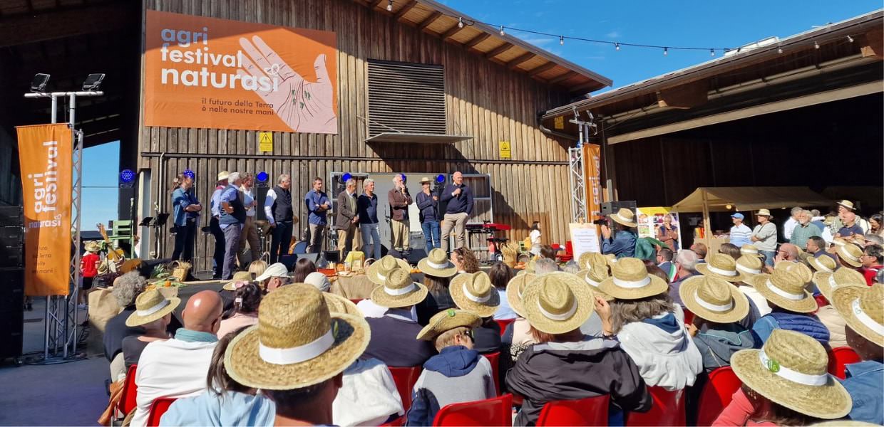 Celebrazione all'Agri Festival di NaturaSì, con oltre tremila persone presenti e relatori sul palco in un ambiente festoso e partecipativo.