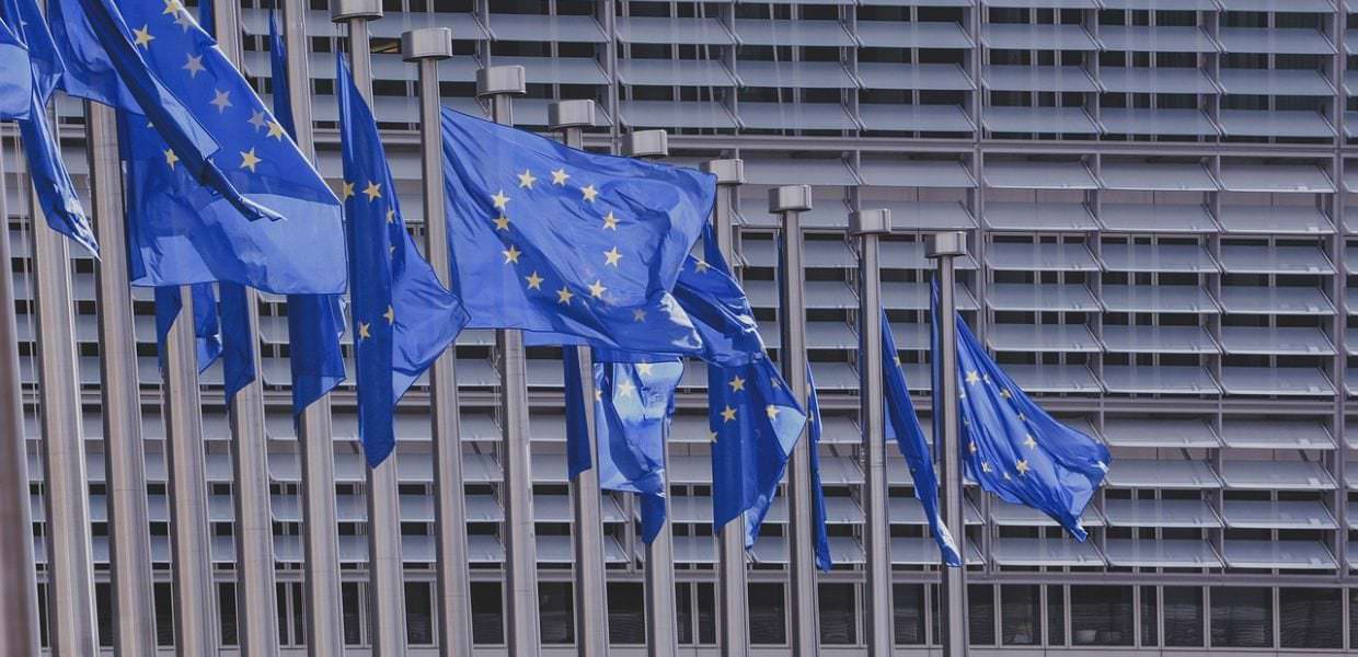 Bandiera dell'Unione Europea che sventola davanti alla Commissione Europea, simbolo del piano Ue per ridurre le emissioni di CO2 attraverso l'aumento delle tasse.