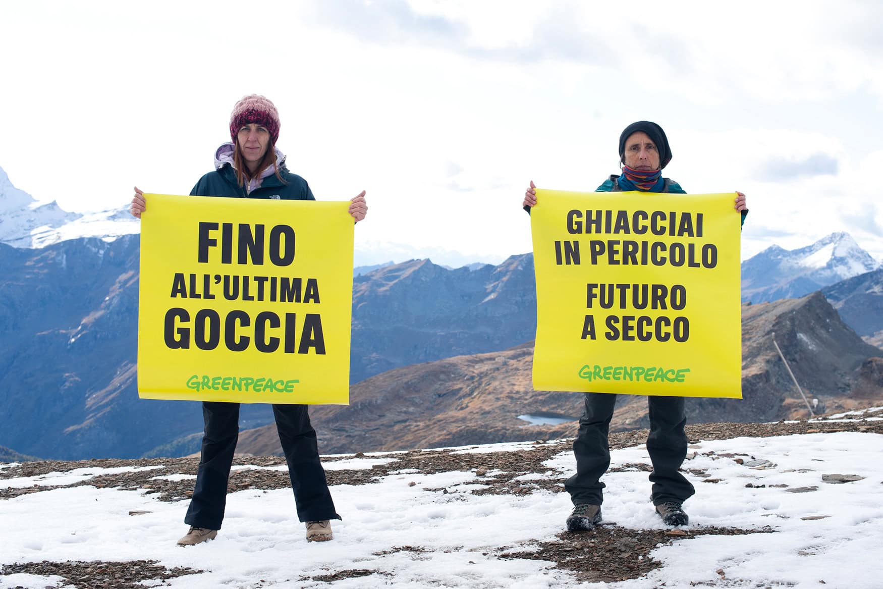Due attivisti Greenpeace mostrano cartelli sul ghiacciaio, chiedendo di fermare il cambiamento climatico e salvaguardare i ghiacciai alpini.