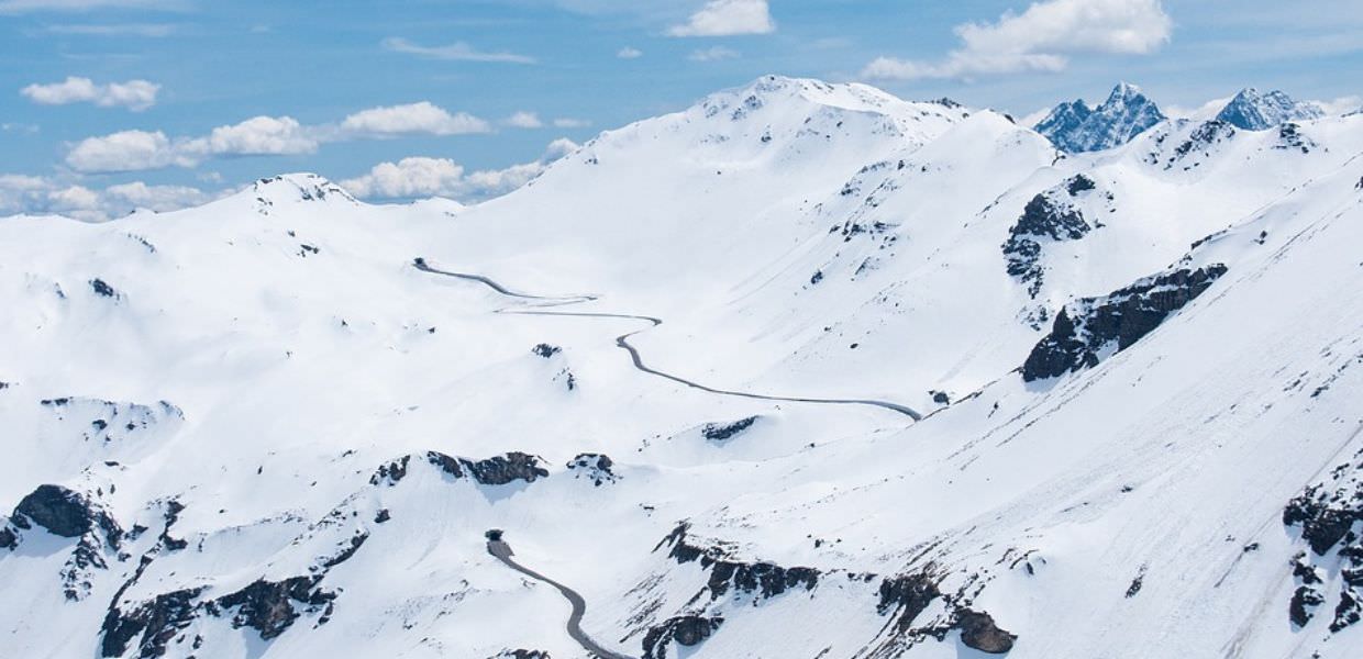 Vista panoramica dei monti innevati, dove il ritiro dei ghiacciai cambia il confine tra Italia e Svizzera. Paesaggio alpino mozzafiato.