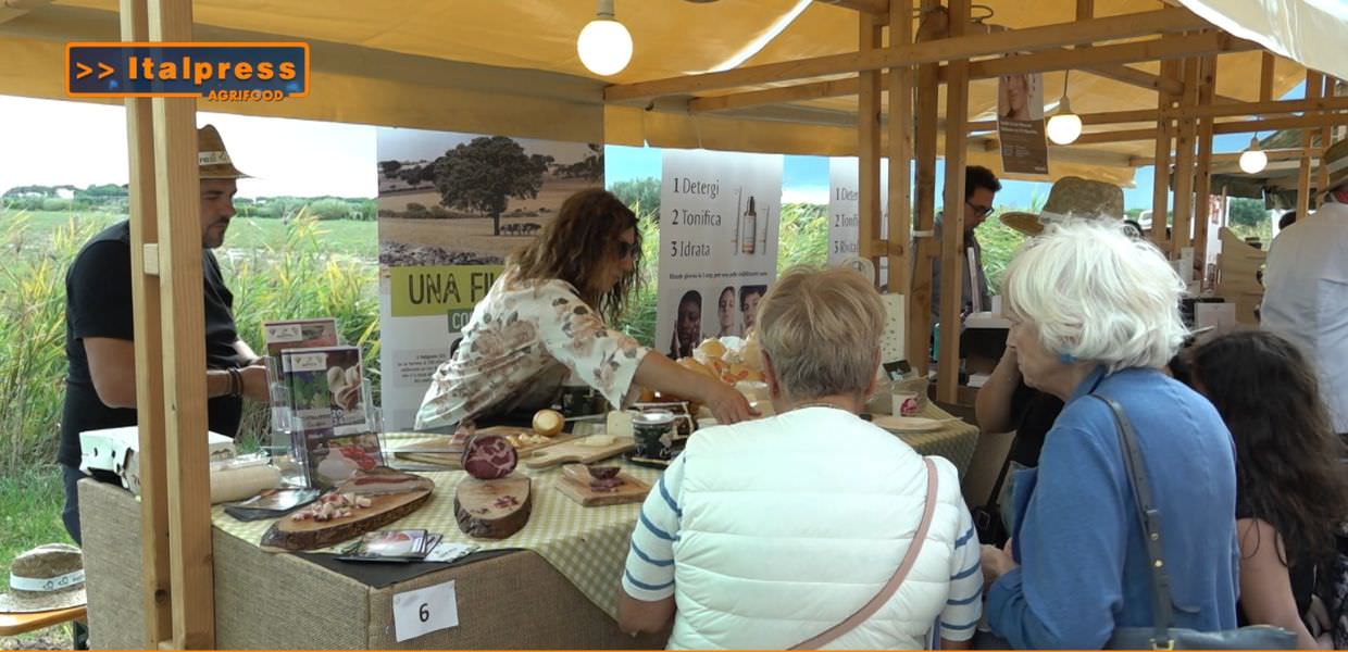 Mercato agricolo al Mar Mediterraneo con persone che esplorano prodotti locali di Eataly e NaturaSì durante il G7 Agricoltura.