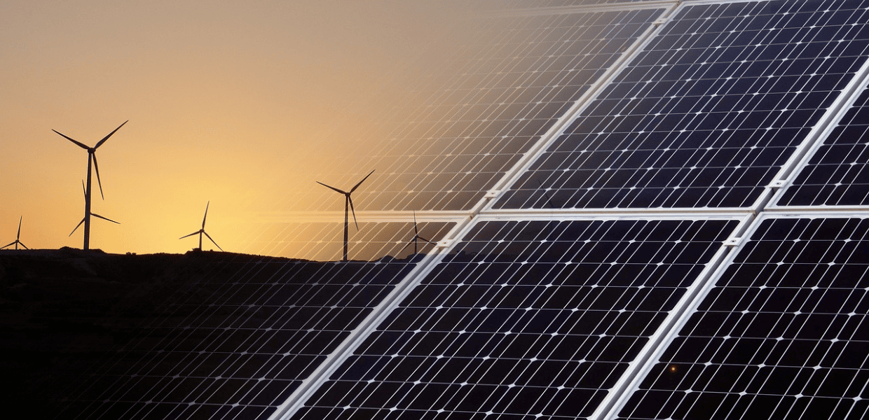 Pannelli solari e turbine eoliche al tramonto, simbolo delle rinnovabili in Italia e dei temi discussi al Renewables Investment Forum.