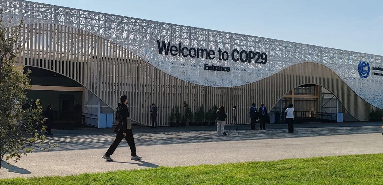 Ingresso della COP29, evento chiave per il clima, con partecipanti e un ambiente che sottolinea l'importanza della sostenibilità globale.