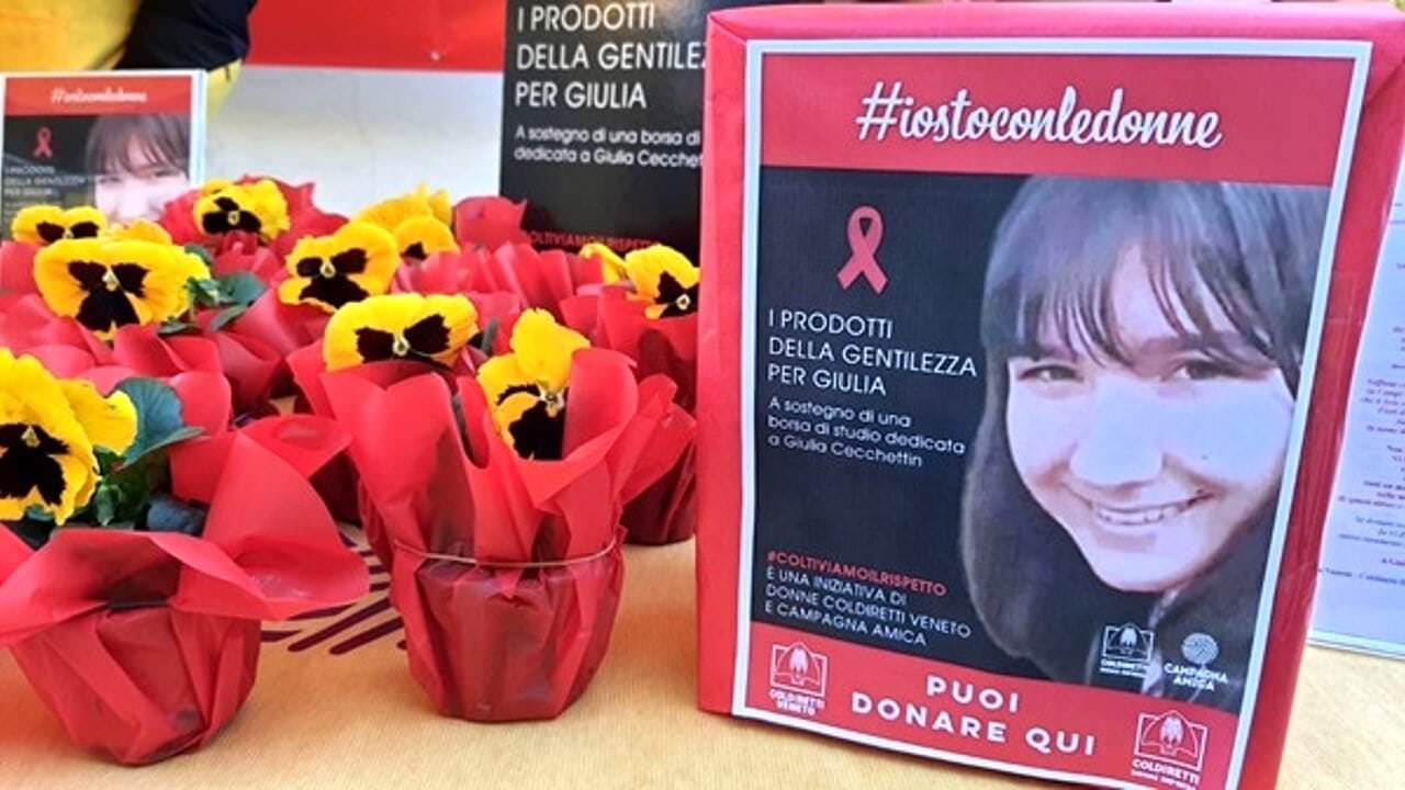 Fiocco rosso in onore di Giulia, simbolo di lotta contro la violenza sulle donne, con fiori e campagne di sensibilizzazione. #iostoconledonne