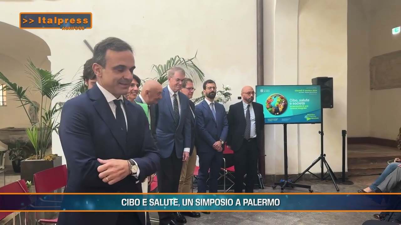 Immagine del simposio 'Cibo e salute' a Palermo, con relatori e partecipanti impegnati nella discussione sull'agricoltura e alimentazione.