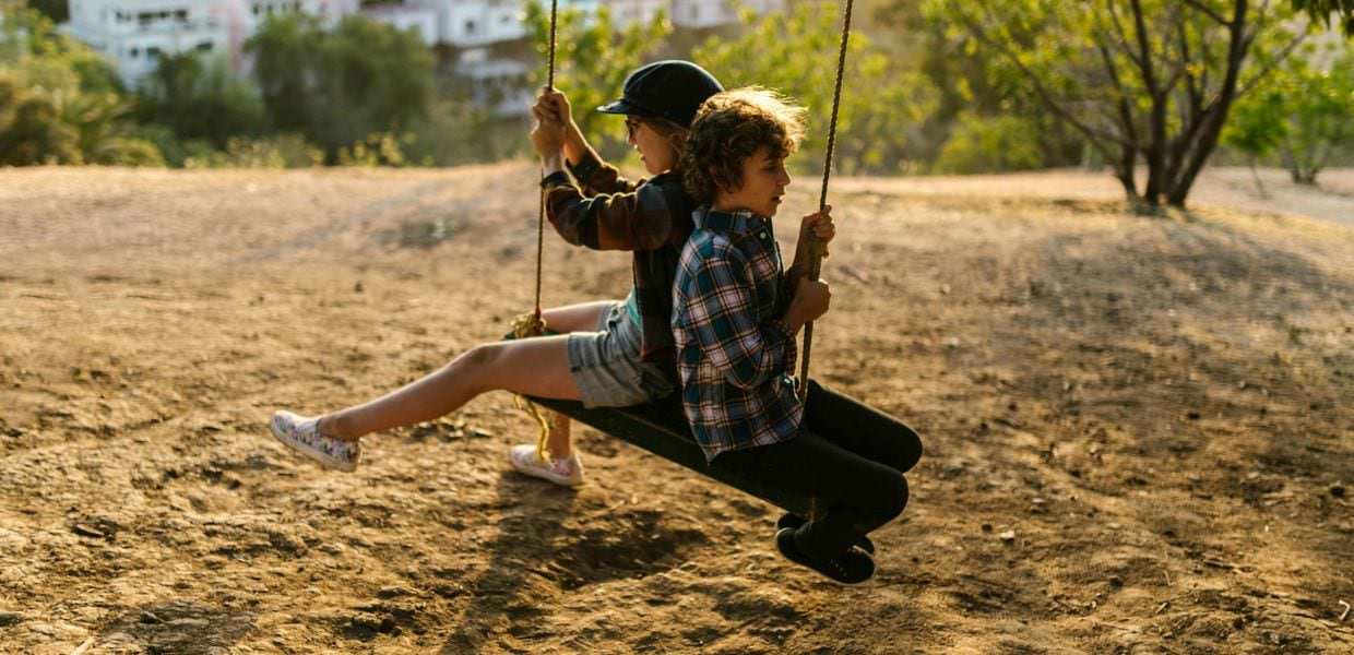 Ecco una possibile alternativa testuale SEO-friendly per l'immagine Domenica-in-famiglia.jpg:

Due bambini felici si divertono su un'altalena durante una giornata all'aria aperta.  Domenica in famiglia: attività all'aperto, giochi e spensieratezza.